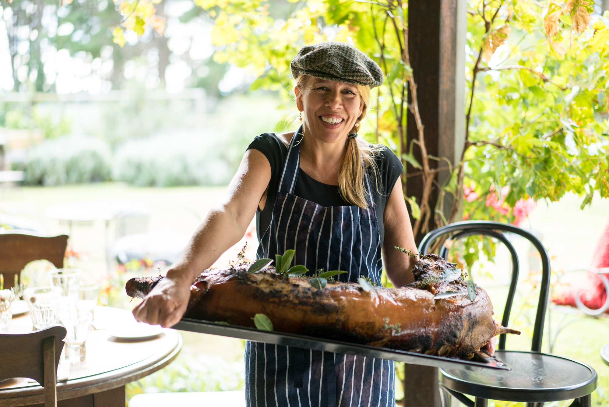 Photograph of Brigid Kennedy with a roast pig